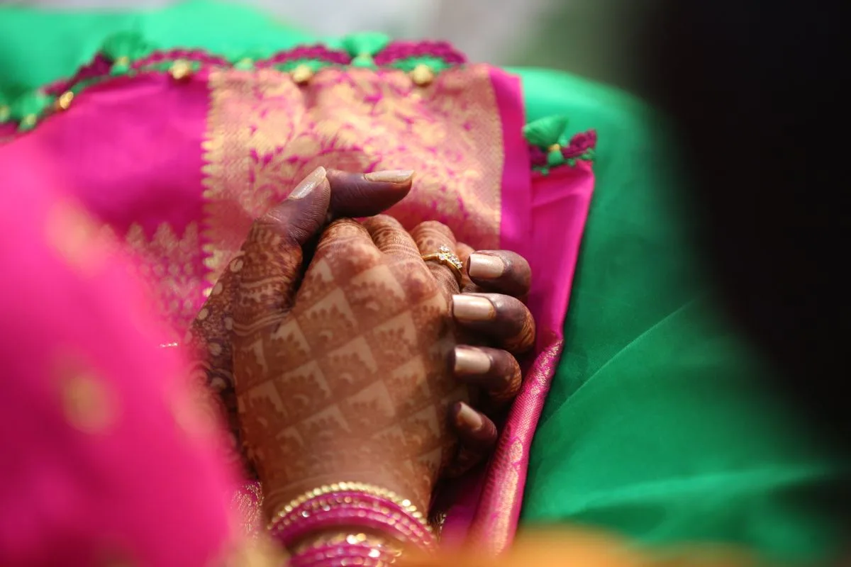 Close-up of intricate mehendi on a bride’s hands during an Indian wedding celebration.